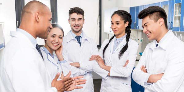 Several individuals in lab coats having a discussion