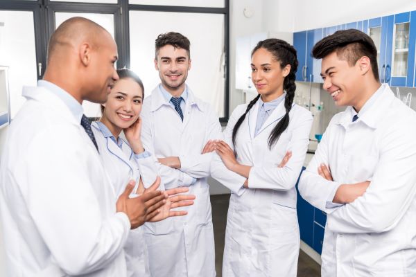 Several individuals in lab coats having a discussion