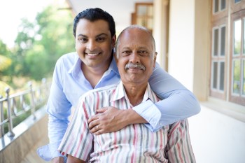 362504621 Closeup portrait, family, young man in blue shirt holding older man in striped shirt from behind, happy isolated on outdoors outside balcony background