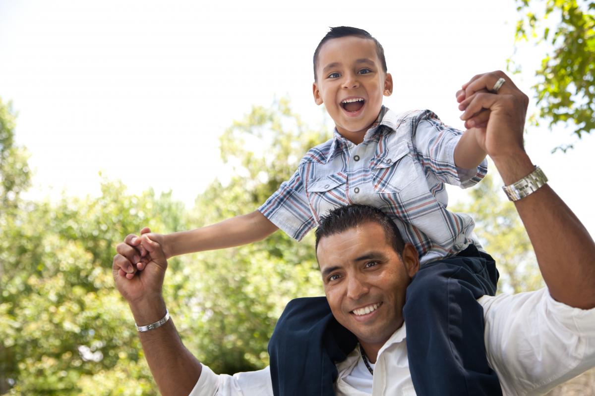 Hispanischer Vater und Sohn haben gemeinsam Spaß im Park.