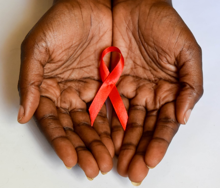 African American hands holding a red ribbon